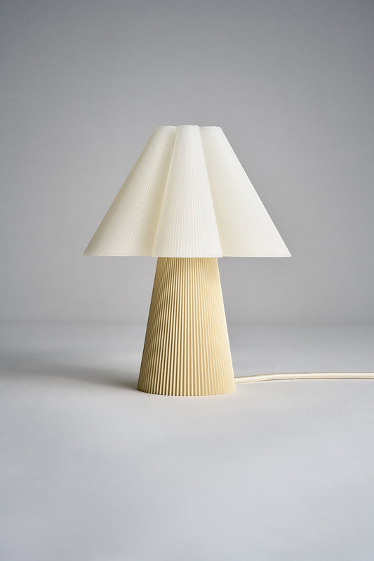 Layerd Bloom Chalk table lamp with pleated cream shade and yellow base made of PLA. Minimalist design.
