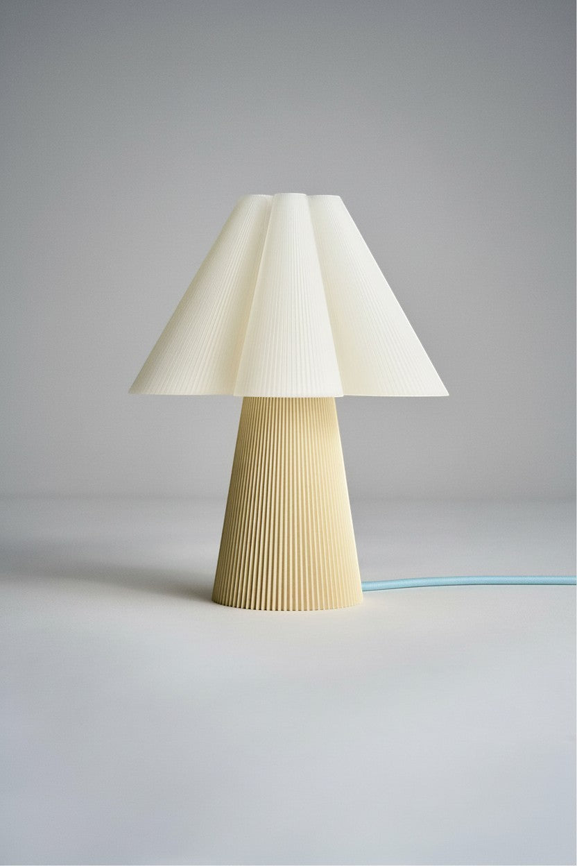 Layerd Bloom Chalk table lamp with pleated cream shade and yellow base, made from PLA.
