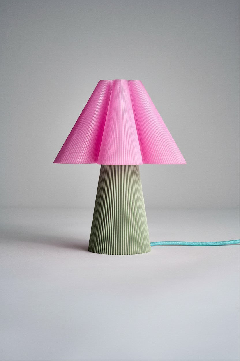 Layerd Bloom Clash table lamp with pink pleated shade and green ribbed base. PLA material.