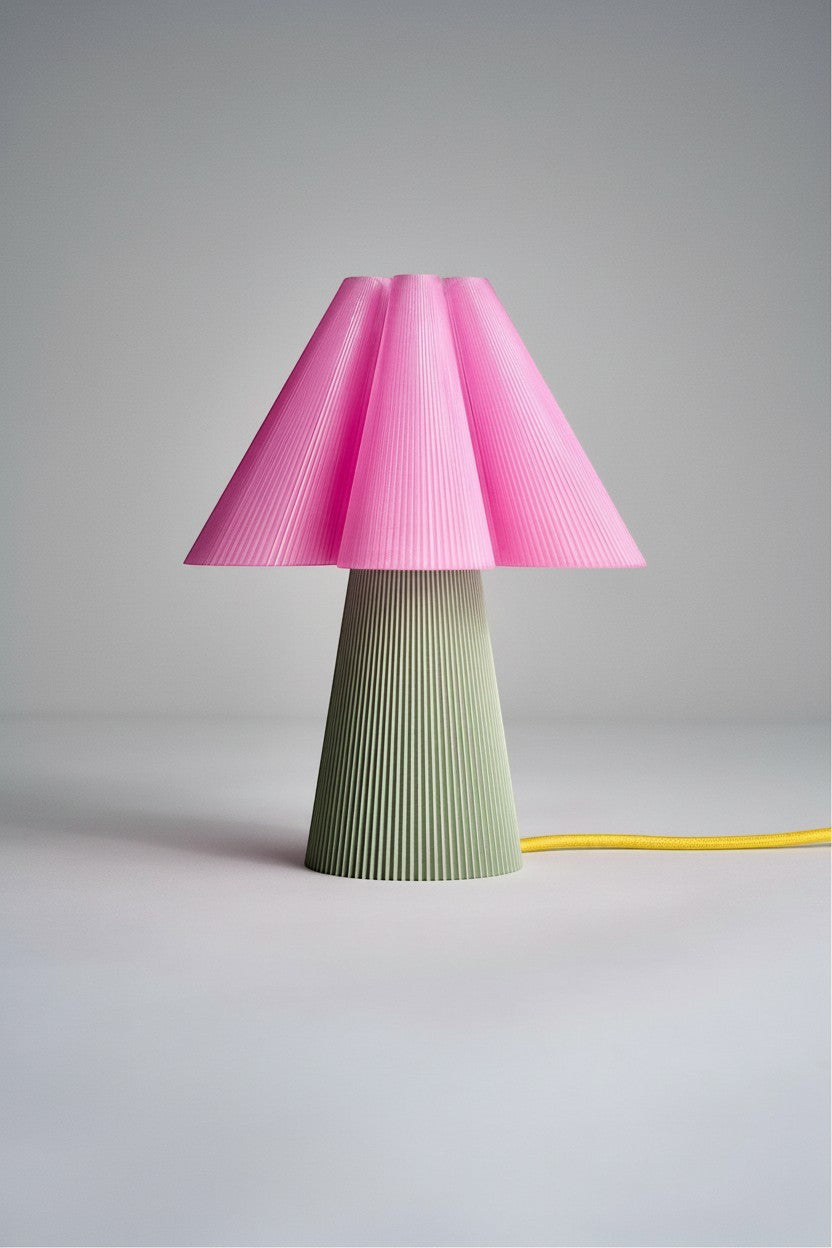 Layerd Bloom Clash table lamp with pink pleated shade and green ribbed base, made of PLA.