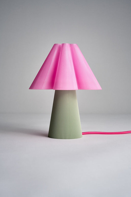 Layerd Bloom Clash table lamp with a pink pleated shade and a sage green ribbed base. PLA material.