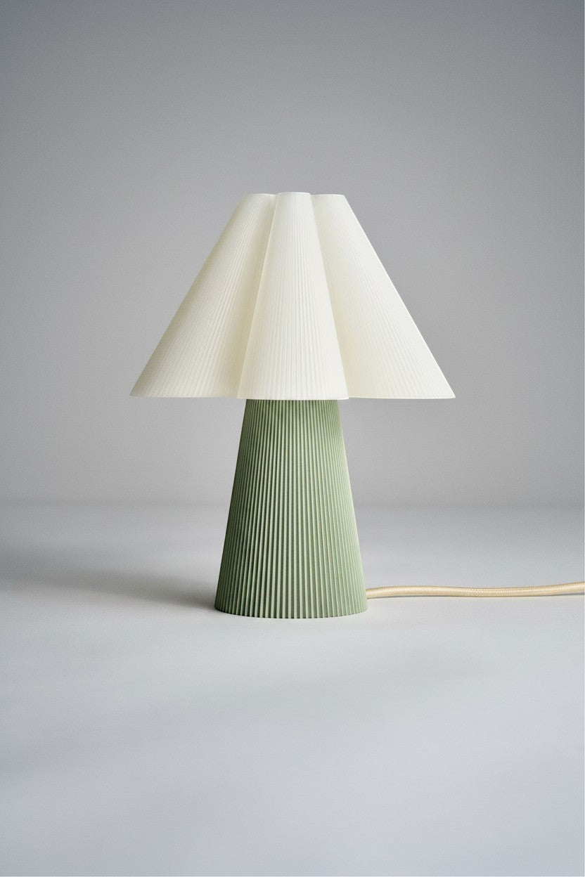 Layerd Bloom Sage table lamp with pleated cream shade and green fluted base made of PLA.